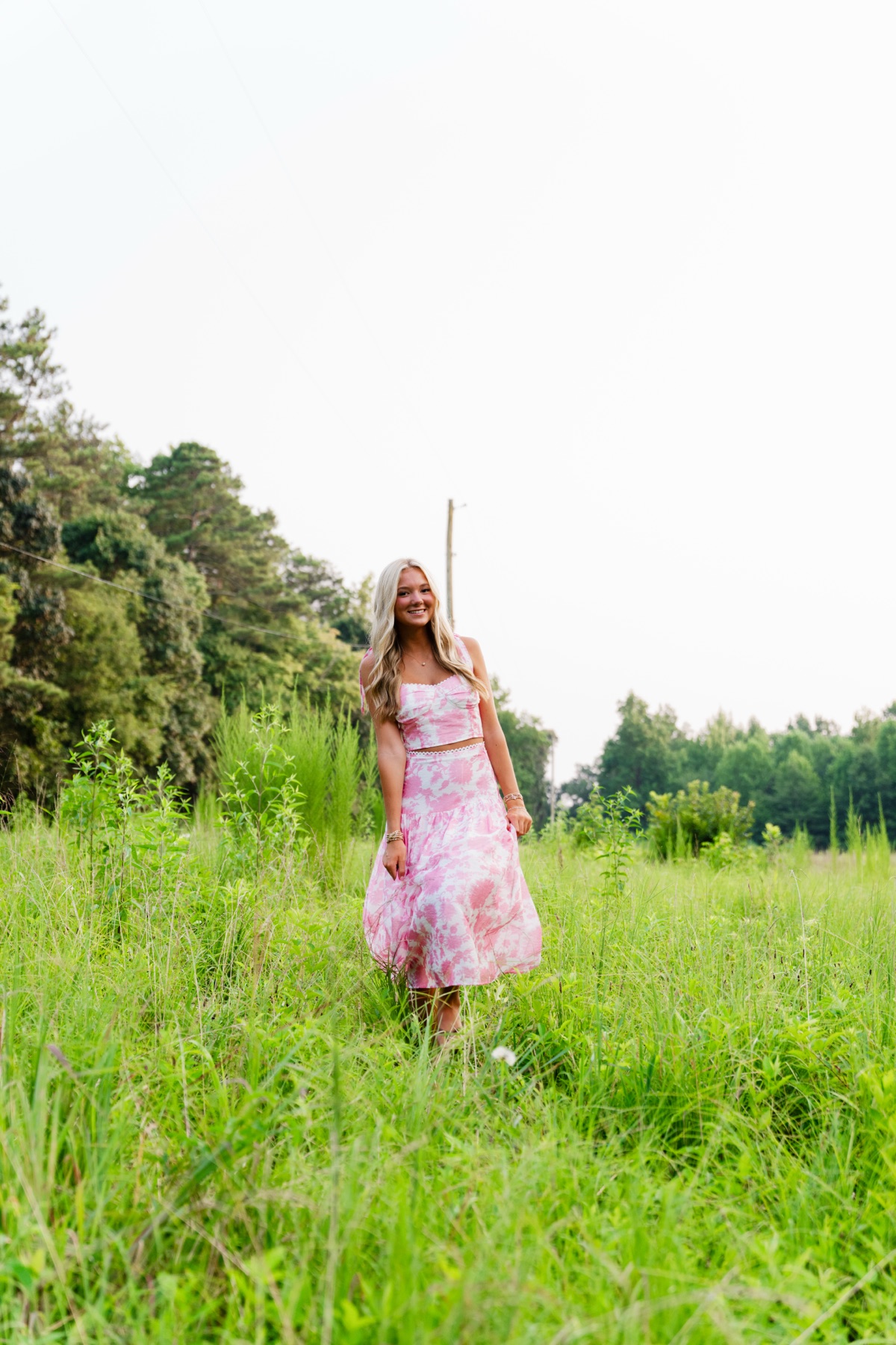 Senior portrait in a pink dress in an open field