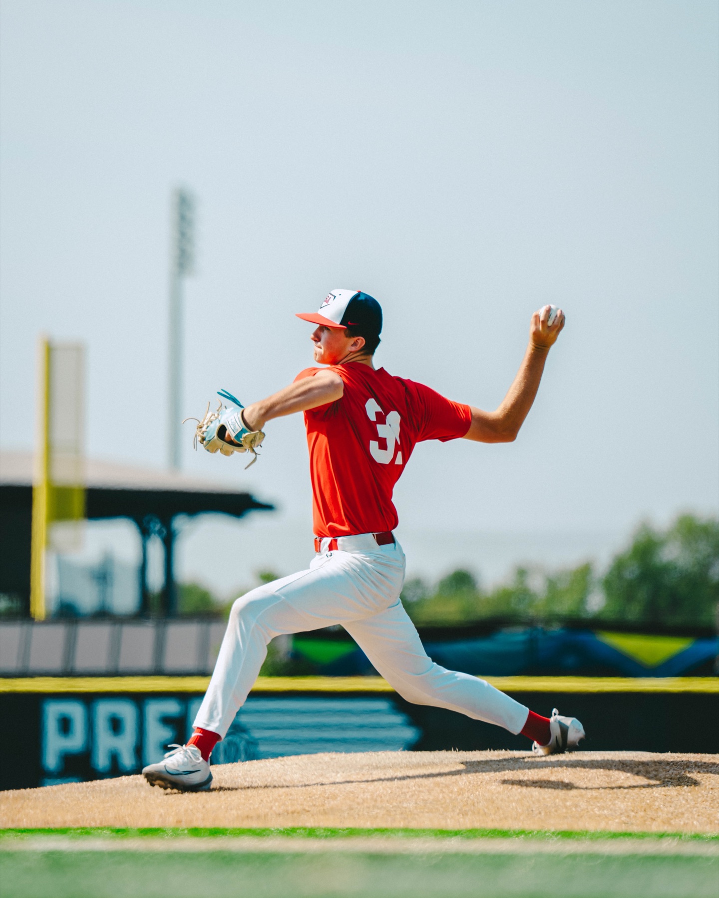 Baseball pitcher throwing in a red uniform