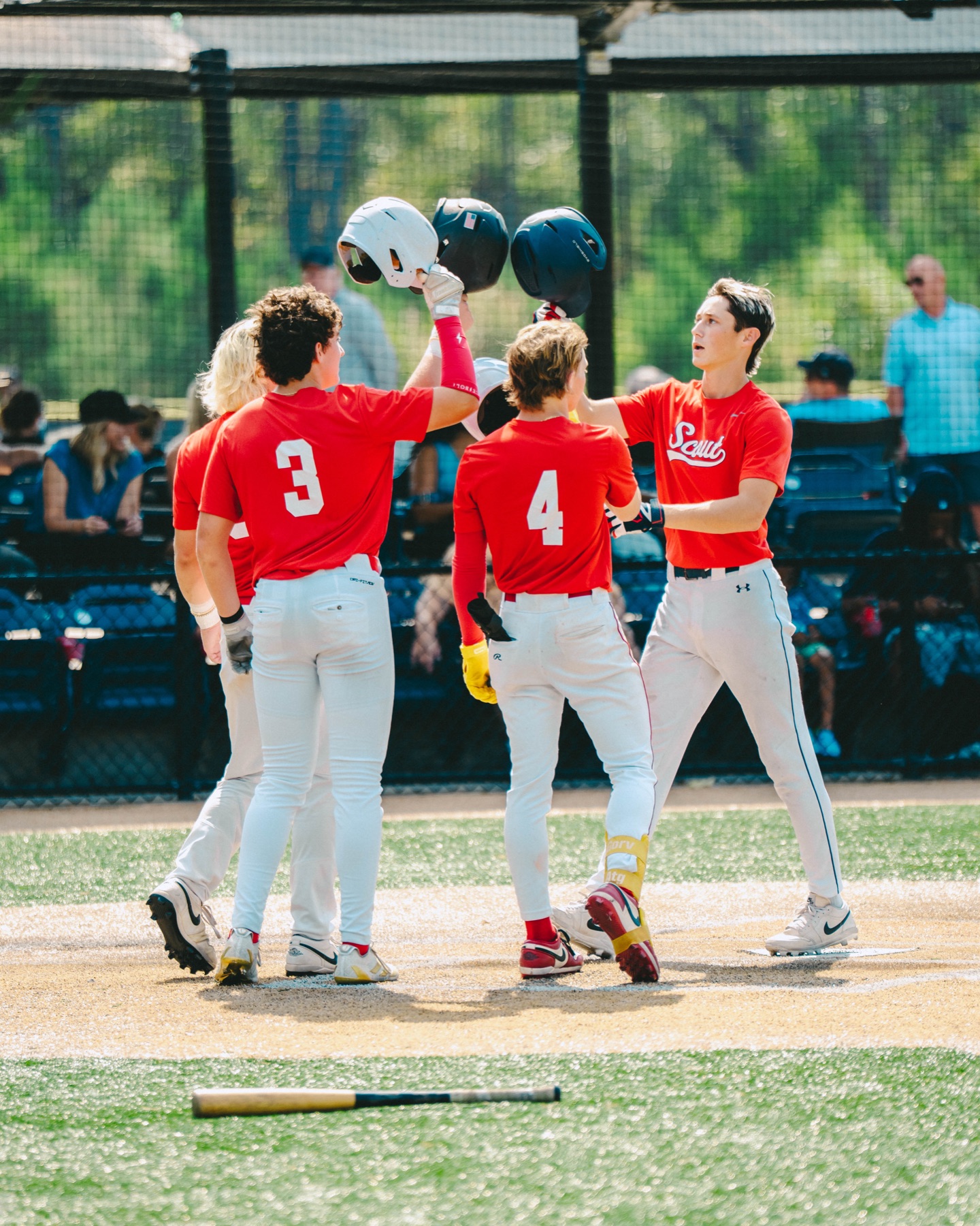 Baseball teammates raising their helmets