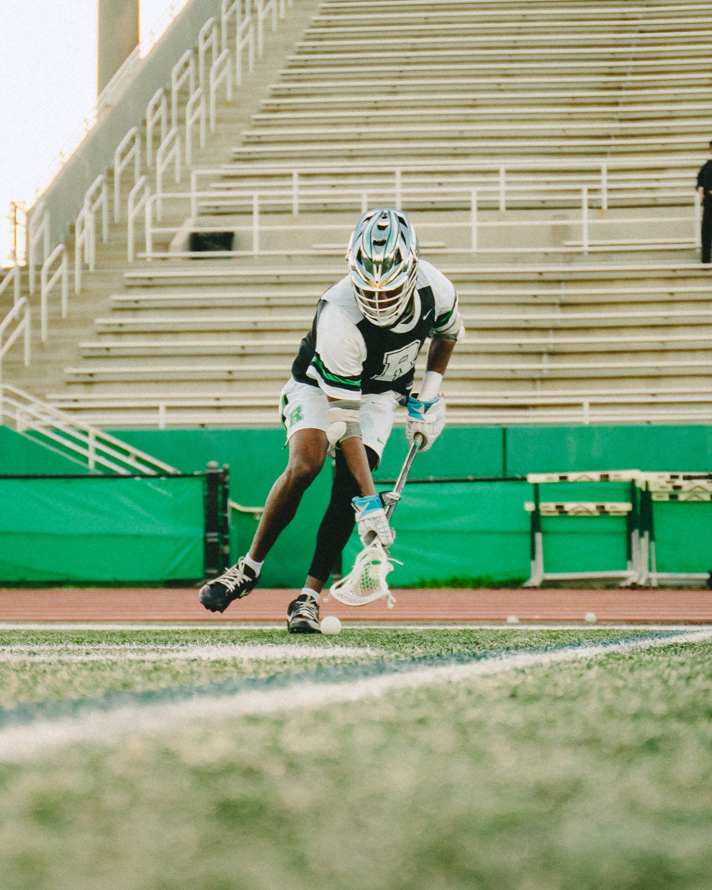 Lacrosse player scooping up the ball