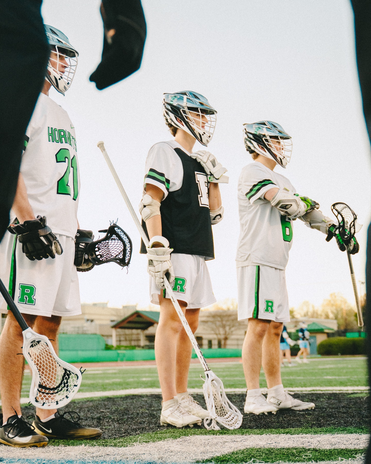 Lacrosse players watching from the sideline